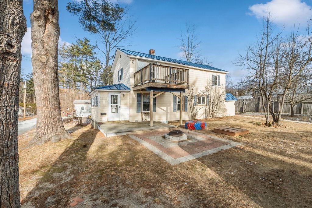 back of house with a balcony and a fire pit