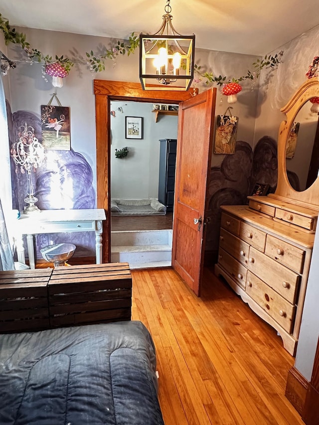 bedroom with light hardwood / wood-style flooring and a chandelier