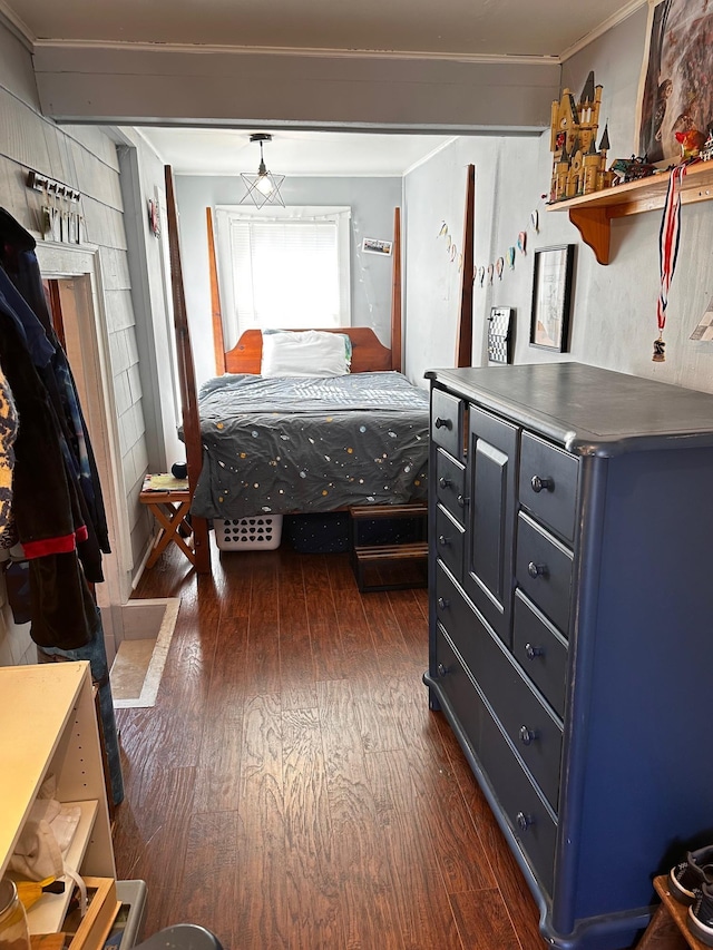 bedroom with dark hardwood / wood-style flooring and crown molding