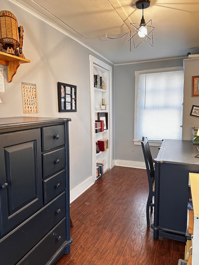 home office with dark hardwood / wood-style flooring, built in features, and crown molding