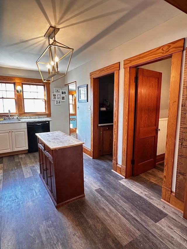 kitchen with sink, an inviting chandelier, black dishwasher, dark hardwood / wood-style floors, and a kitchen island