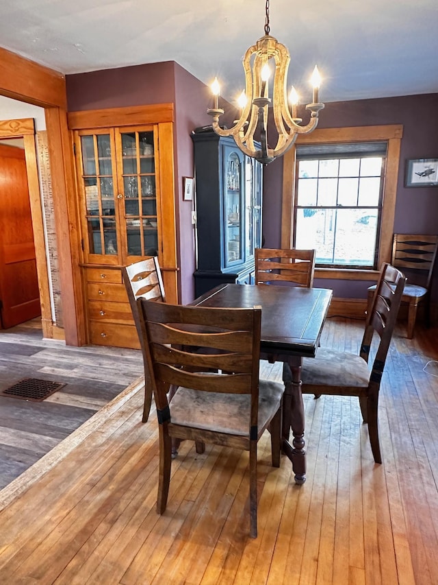 dining area with an inviting chandelier and hardwood / wood-style flooring