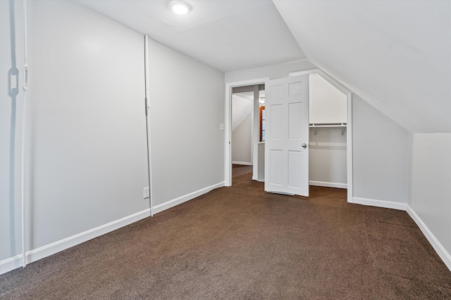 bonus room featuring dark carpet and lofted ceiling