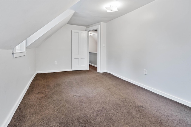 bonus room featuring dark colored carpet and vaulted ceiling