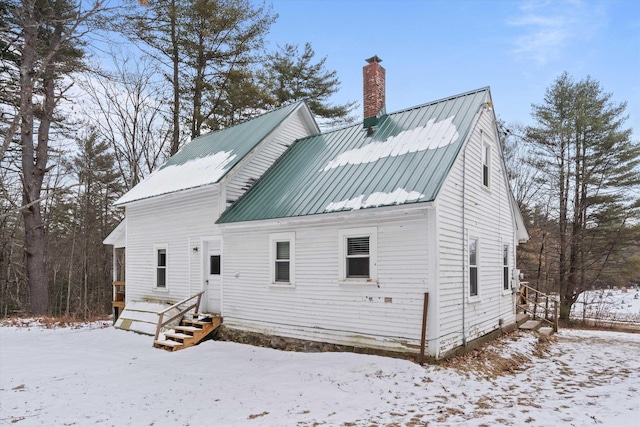 view of snow covered back of property