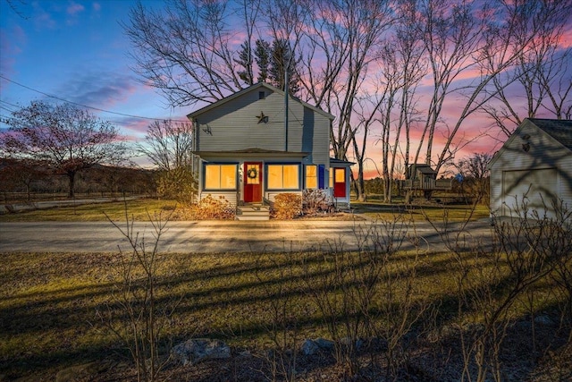 view of front of home with a garage and an outbuilding