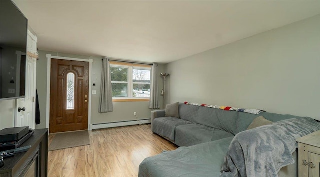 living room featuring a baseboard heating unit and light hardwood / wood-style floors