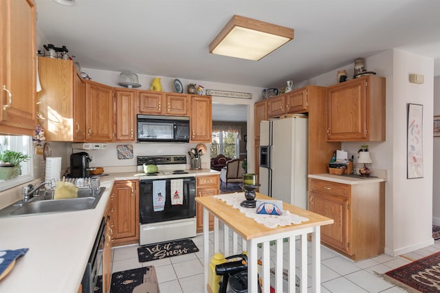 kitchen with black appliances, light tile patterned flooring, and sink