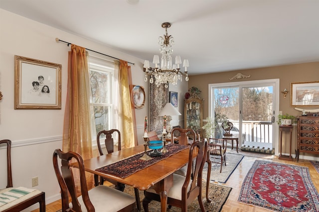 dining space with light parquet floors, a chandelier, and plenty of natural light