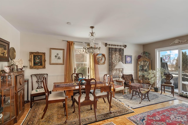 dining area with an inviting chandelier and parquet flooring