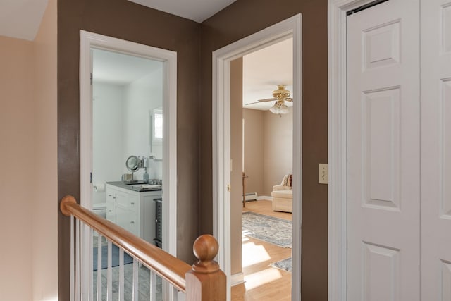 hallway featuring baseboard heating and hardwood / wood-style floors