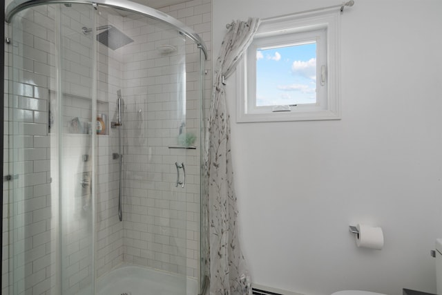 bathroom with toilet and a shower with shower door