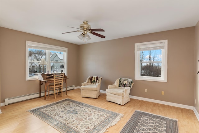 living area featuring ceiling fan, baseboard heating, and hardwood / wood-style flooring