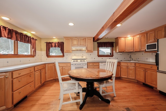 kitchen featuring sink, white appliances, light hardwood / wood-style flooring, and beam ceiling