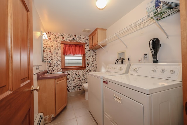 washroom featuring sink, light tile patterned floors, a baseboard heating unit, and separate washer and dryer