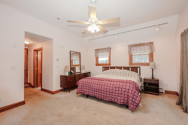 carpeted bedroom featuring ceiling fan, a baseboard heating unit, and rail lighting