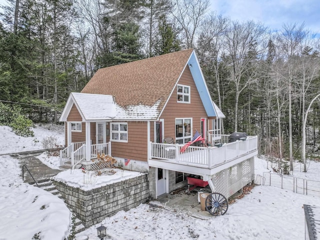 snow covered property with a deck