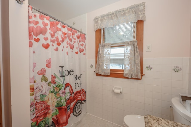 bathroom with tile walls, curtained shower, and toilet