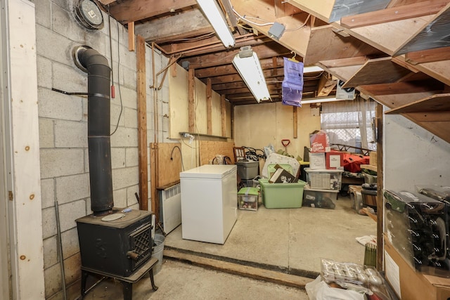 basement featuring fridge and a wood stove