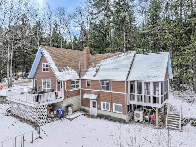 snow covered property with a sunroom