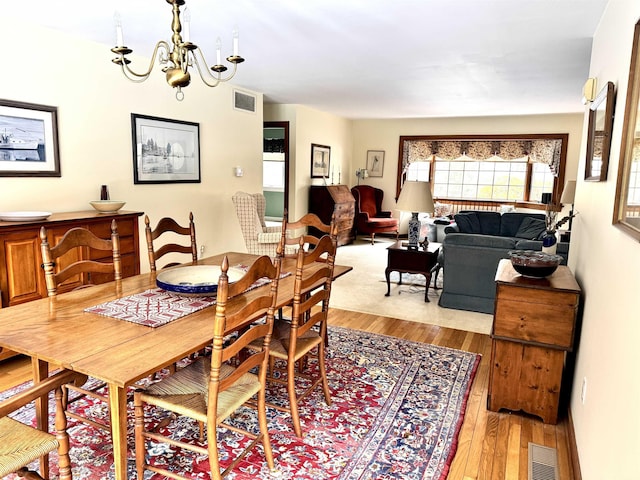 dining area featuring a notable chandelier and light hardwood / wood-style flooring