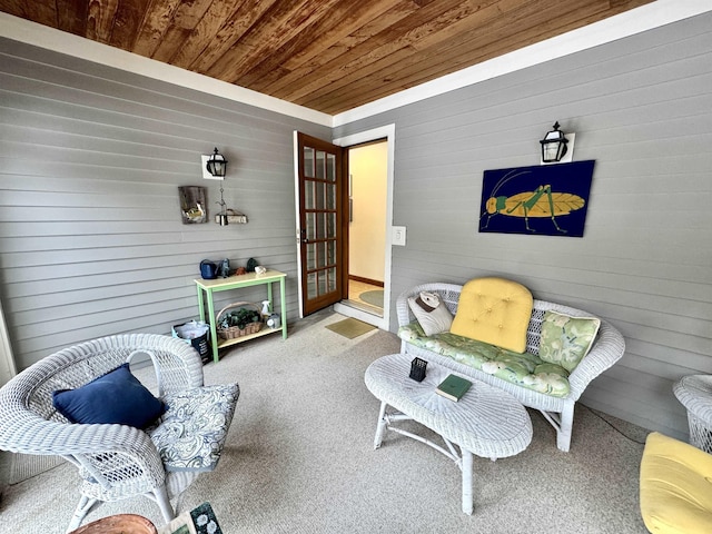 living area with wood walls, carpet floors, and wooden ceiling