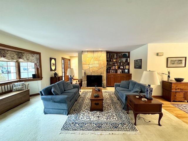 living room with a fireplace, built in shelves, and light hardwood / wood-style flooring