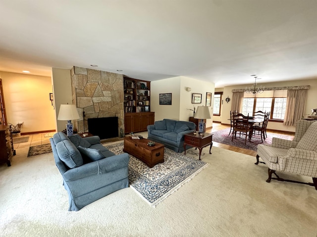 living room featuring an inviting chandelier, a fireplace, and carpet flooring