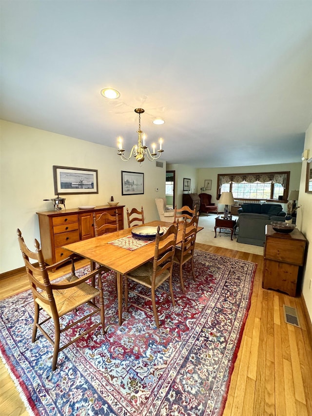 dining room with a notable chandelier and light hardwood / wood-style flooring