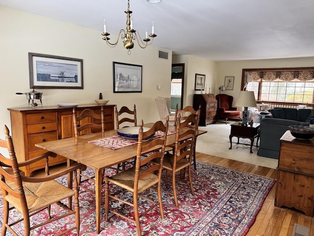 dining area featuring light hardwood / wood-style floors and an inviting chandelier