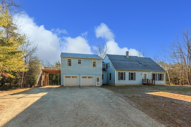 back of property featuring a garage and a wooden deck