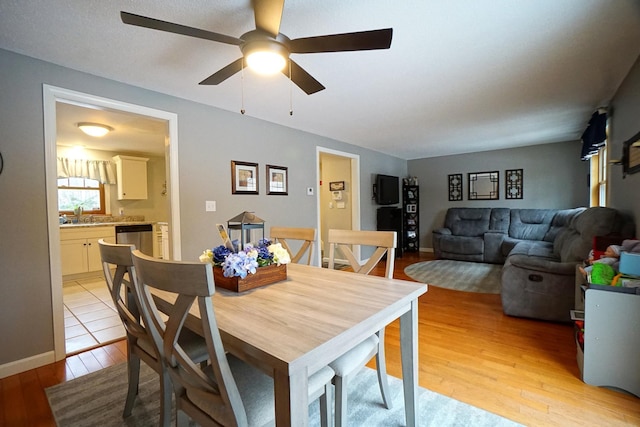 dining space featuring light wood-type flooring and ceiling fan