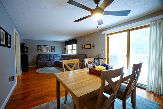 dining room with wood-type flooring, a textured ceiling, ceiling fan, and plenty of natural light