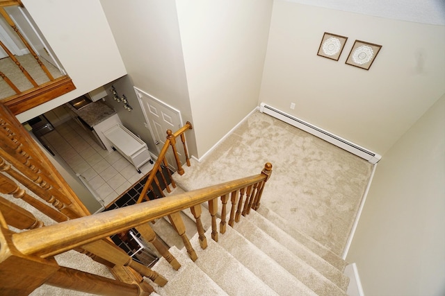 stairway featuring carpet flooring and a baseboard heating unit