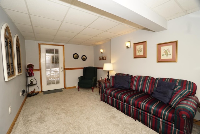 carpeted living room featuring a drop ceiling