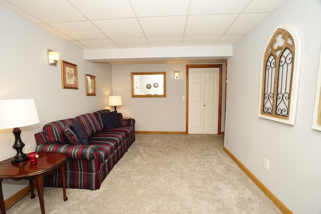 living room with a paneled ceiling and carpet