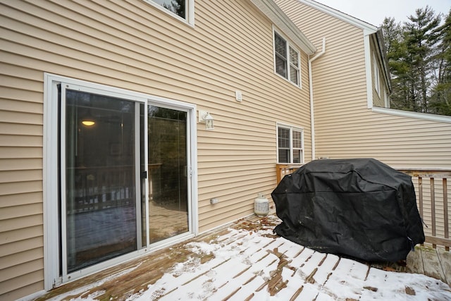 snow covered deck with a grill