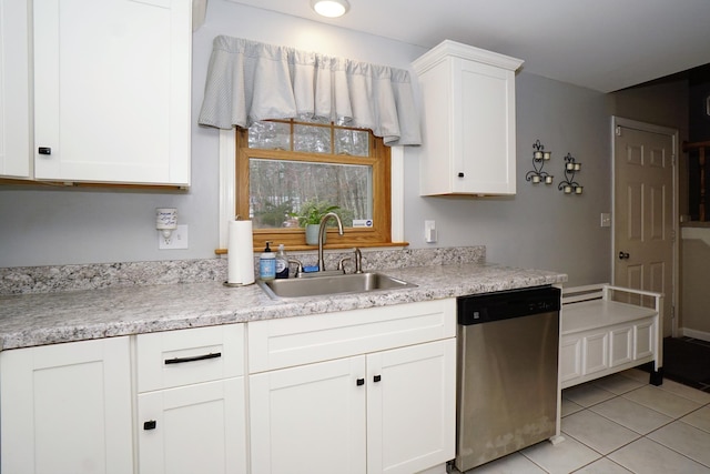 kitchen featuring sink, light tile patterned floors, white cabinets, and dishwasher