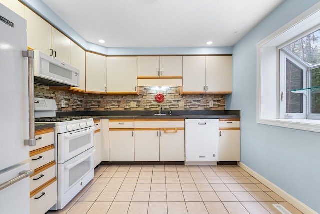 kitchen with white appliances, decorative backsplash, and sink