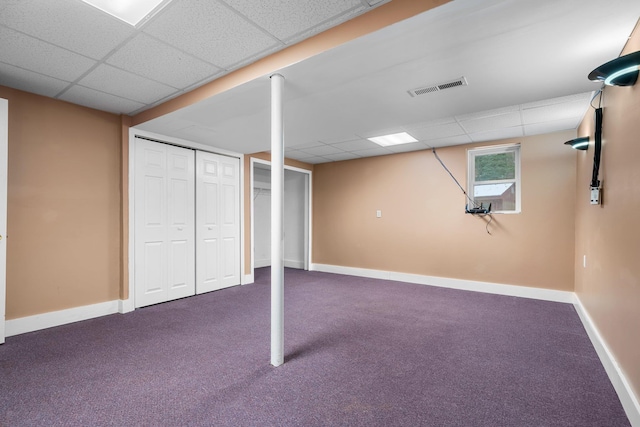 basement with a paneled ceiling and carpet floors