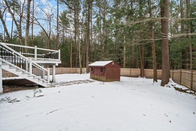 snowy yard with a storage shed