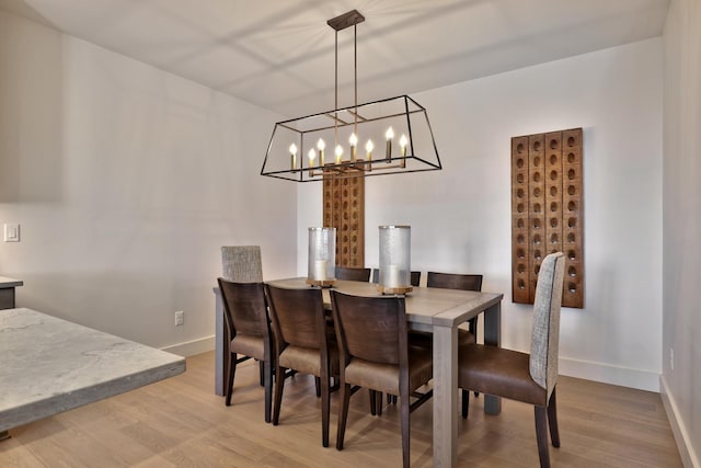 dining area featuring an inviting chandelier and light hardwood / wood-style floors