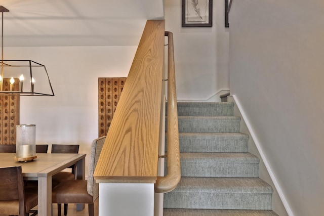 stairs featuring a chandelier