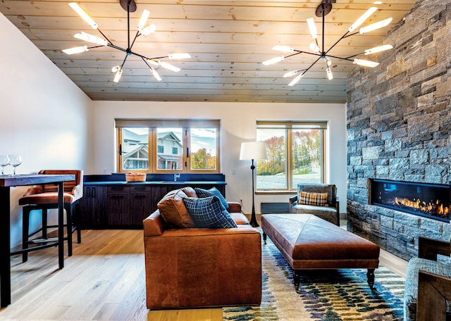 living room featuring light hardwood / wood-style flooring, a stone fireplace, wood ceiling, and vaulted ceiling