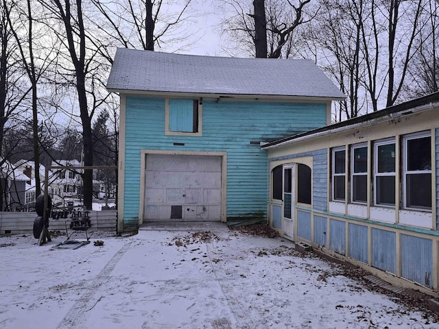 view of snowy exterior with a garage