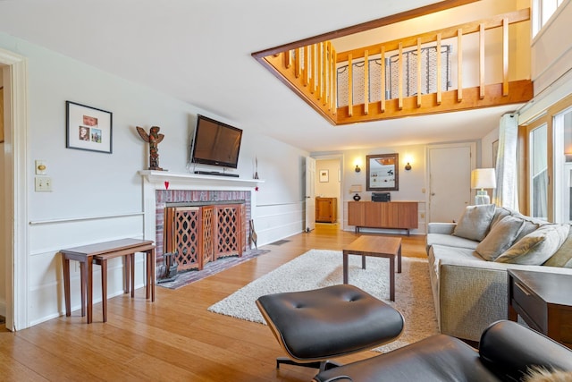 living room featuring a brick fireplace and light hardwood / wood-style floors