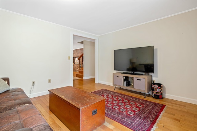 living room with light wood-type flooring and crown molding