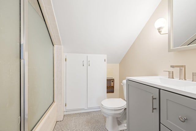 full bathroom featuring bath / shower combo with glass door, vaulted ceiling, vanity, and toilet