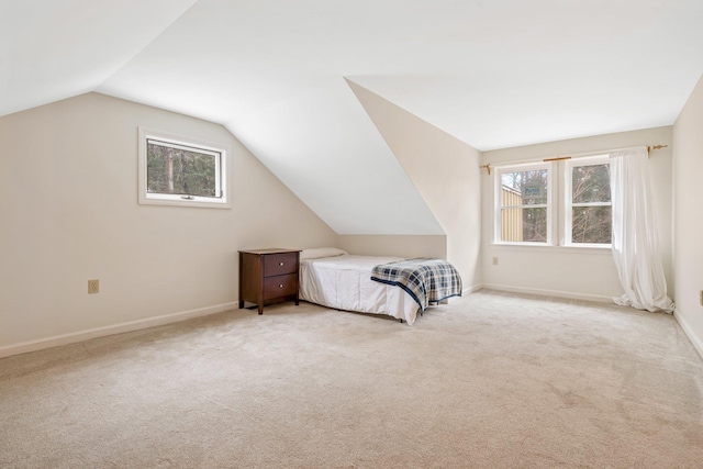 bedroom with light colored carpet and lofted ceiling