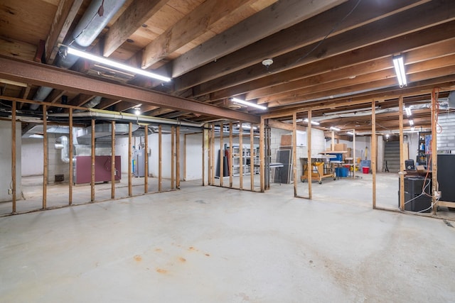 basement featuring gas water heater and heating unit